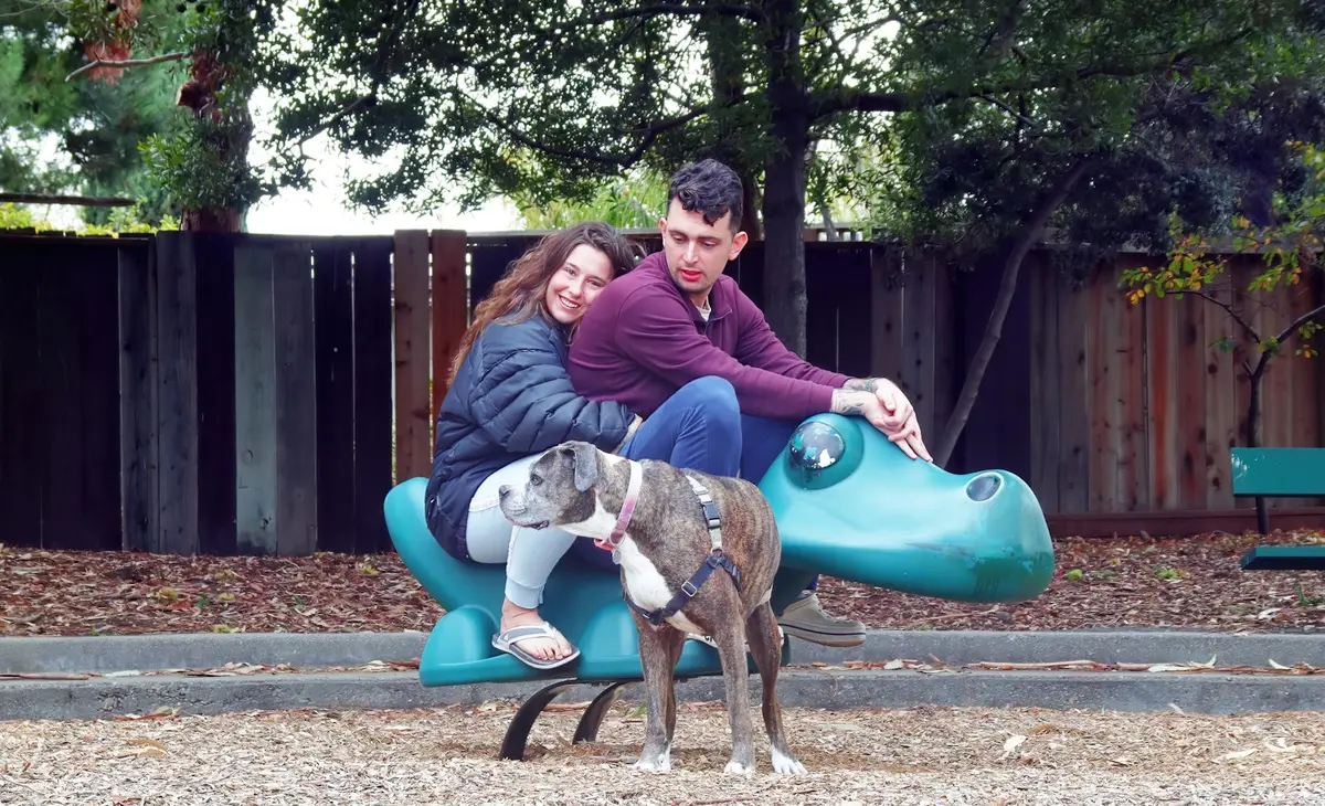 A couple relaxing outdoors with their dog